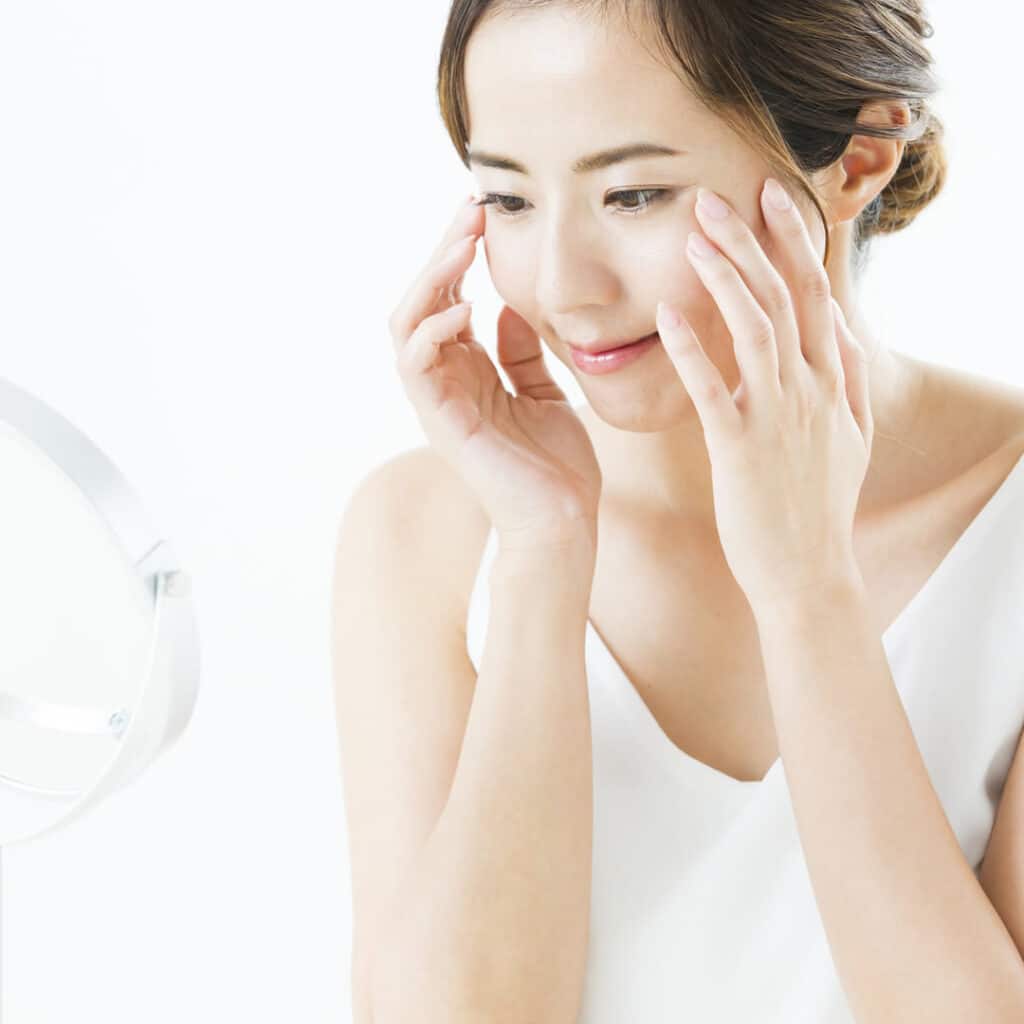 鏡で目元を確認している女性