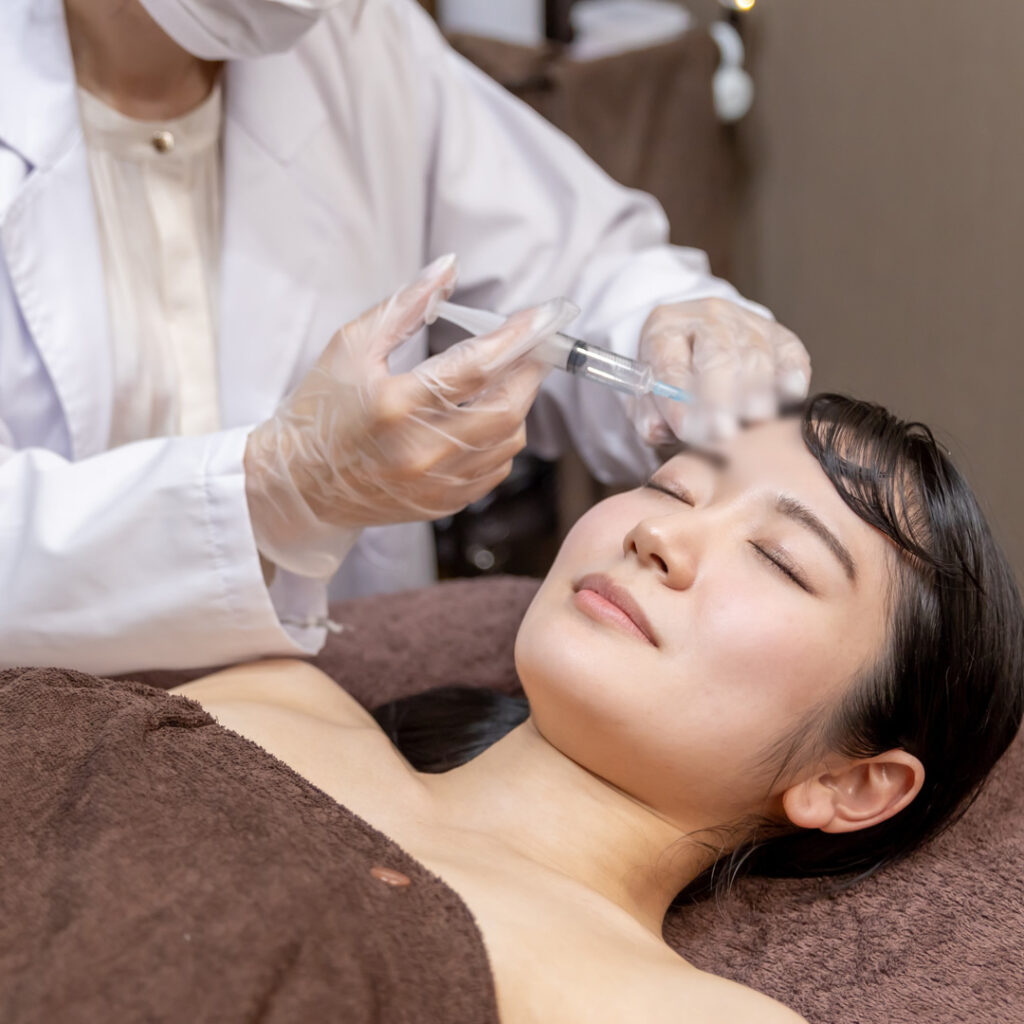 こめかみにヒアルロン酸を注入しているイメージ