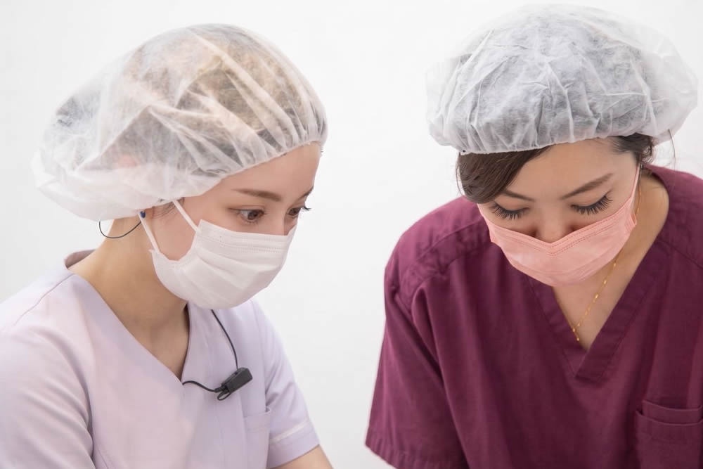 後輩に仕事を教えている看護師